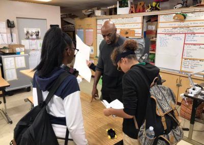 Lyle Rushing looks over the drawing book of one of the AP Drawing class students.